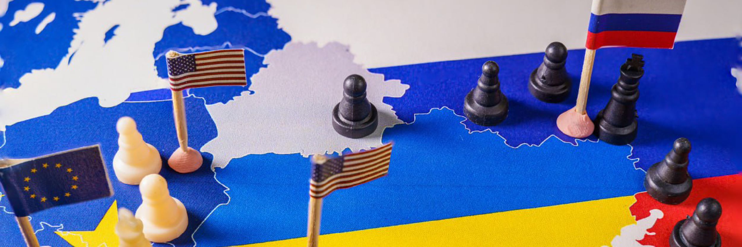 Drapeaux de l'UE, des États-Unis et de la Russie avec des pièces d'échecs symbolisant le conflit et le contrôle de l'Ukraine